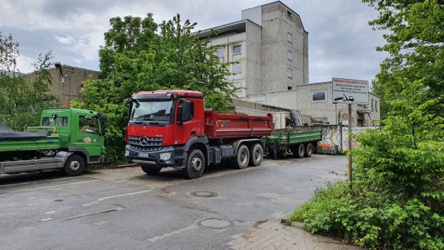 Abgestelle Baufahrzeuge vor dem ehemaligen Postlerheim